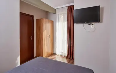 a bedroom with a bed and a flat screen tv at Bendita House in Pomorie