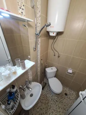 a bathroom with a toilet and a sink and a shower at Downtown Apartment Varna in Varna City