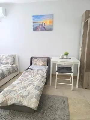 a bedroom with a bed and a table and a desk at Downtown Apartment Varna in Varna City