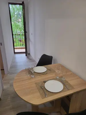 a wooden table with plates and wine glasses on it at Aleks Top Center 2- Free parking in Burgas City
