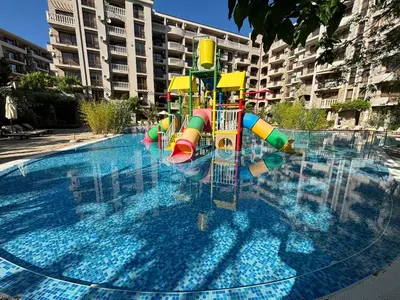 a swimming pool with a playground in a building at Studio/free yoga&aqua aerobic in Sunny Beach