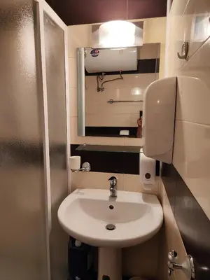 a small bathroom with a sink and a mirror at Nev in Burgas City
