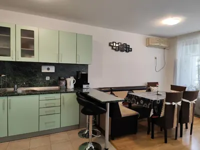 a kitchen with green cabinets and a table with chairs at Nev in Burgas City