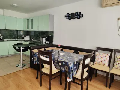 a dining room with a table and chairs and a kitchen at Nev in Burgas City