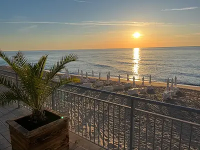 a view of the beach at sunset from a balcony at Summer Rose Studio by the Sea in Byala