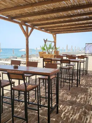 a row of tables and chairs on the beach at Summer Rose Studio by the Sea in Byala