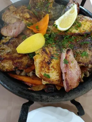 a pan of food with chicken and vegetables on a table at Pomorie Chaika Home in Pomorie
