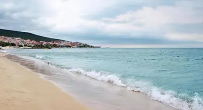 a beach with the ocean and buildings in the background at Premium Ferienwohnung SWETI WLAS Polarstar Beach Luxury Apartment 150 m zum Strand Pool 3 Balkone Meeresblick Google TV bis zu 6 Personen in Sveti Vlas