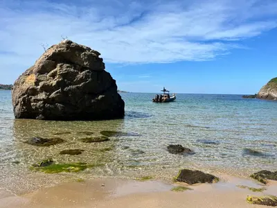 a boat in the water next to a large rock at Good Mood Studio in Green Life First Line in Sozopol
