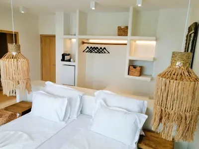 a white couch with white pillows in a room at PARADISE Bay Hotel in Sozopol