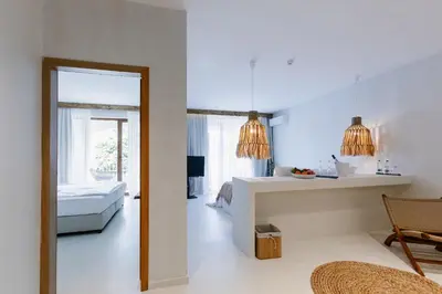 a white room with a bed and a mirror at PARADISE Bay Hotel in Sozopol