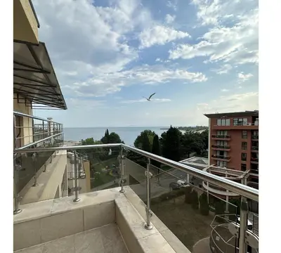 a bird flying over a balcony with a view of the ocean at Seaside Apartment Nesebar in Nesebar