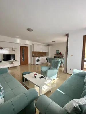 a living room with blue couches and a table at Seaside Apartment Nesebar in Nesebar