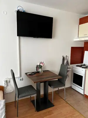 a dining room table with chairs and a television on a wall at Peter Apartmanbulgaria-Imperial Fort Noks in Elenite