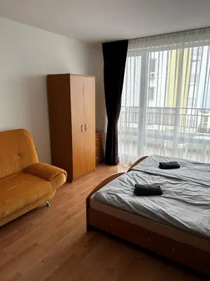 a bedroom with a bed and a couch and a window at Peter Apartmanbulgaria-Imperial Fort Noks in Elenite