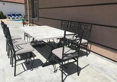 a wooden table and chairs on a patio at Апартамент за гости ДЕНИЦА in Obzor