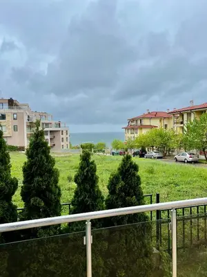 a group of trees in a field with buildings at Black Sea Breeze Apartment No 3 in Byala