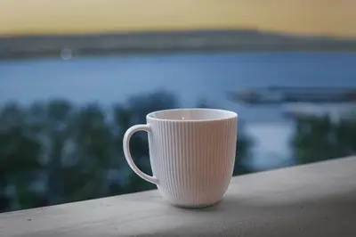 a white coffee cup sitting on a ledge at Marina Varna Apartment-2BDR at South Bay Complex in Varna City