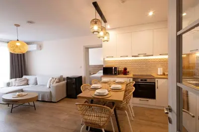 a kitchen and living room with a table and a couch at Marina Varna Apartment-2BDR at South Bay Complex in Varna City