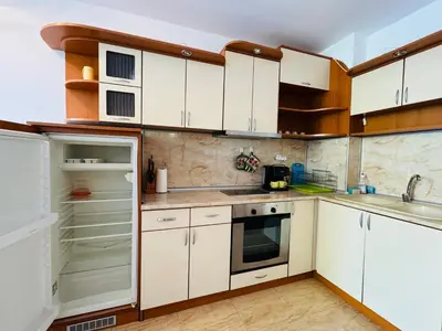 a kitchen with white cabinets and an open refrigerator at SUN VILLAGE B 320 Apartment Sunny Beach in Sunny Beach
