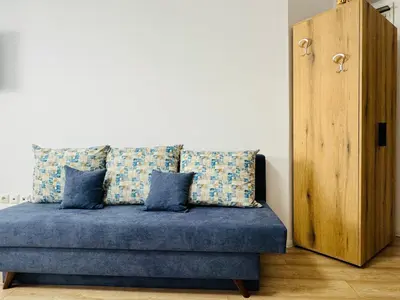 a couch with blue pillows in a room at ROYAL PALM 84 Studio Sveti Vlas in Sveti Vlas