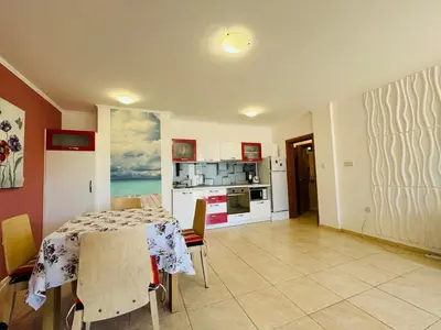 a dining room with a table and a kitchen at VODENICATA 3 Apartament Sveti Vlas in Sveti Vlas