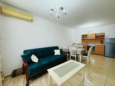 a living room with a blue couch and a table at VODENICATA 4-10 Apartment Sveti Vlas in Sveti Vlas