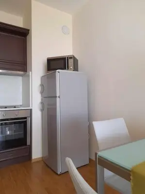 a kitchen with a refrigerator with a microwave on top of it at Sunrise apartment 2 bedrooms in Obzor
