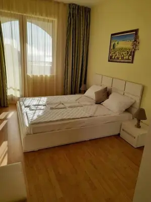 a bedroom with a large white bed in front of a window at Sunrise apartment 2 bedrooms in Obzor