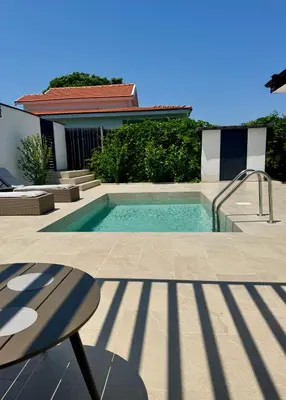 a swimming pool in front of a house at Courtyard Villa, Aleksandrovo in Aleksandrovo
