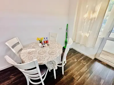 a dining room table with white chairs and a table with flowers on it at 