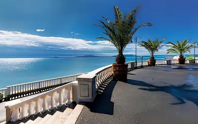 a walkway next to the water with a fence at 