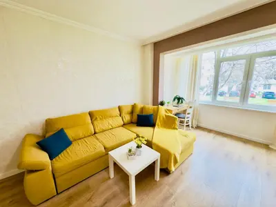 a living room with a yellow couch and a table at 