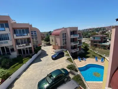 a car parked in a parking lot next to a pool at Black Pearl Apartment in Sozopol