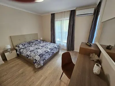 a bedroom with a bed and a table and a chair at Serenity in the heart of Varna with free parking in Varna City