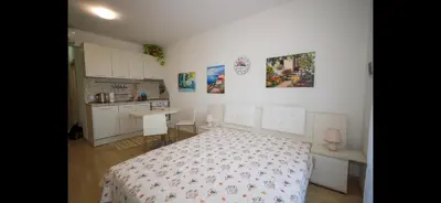 a small bedroom with a bed and a kitchen at Студио Сарафово in Burgas City