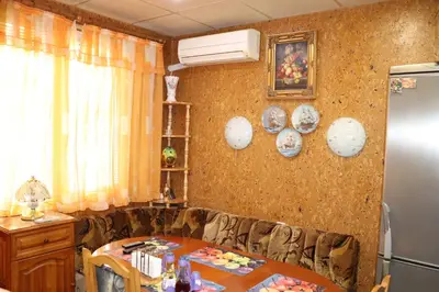 a dining room with a table and a refrigerator at Супер апартамент-център Варна in Varna City