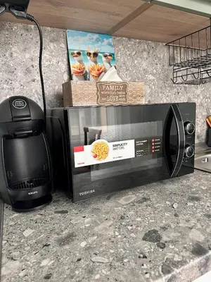 a microwave sitting on a counter next to a stove at Glarus Apartment with Infinity Sea View in Varna City
