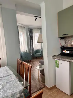 a kitchen and living room with a table and chairs at Glarus Apartment with Infinity Sea View in Varna City