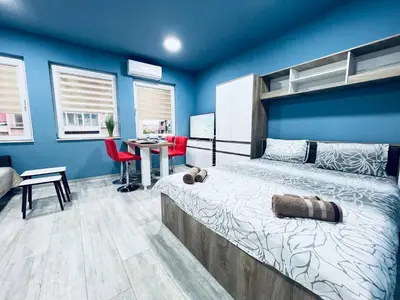 a bedroom with a bed with a blue wall at NJ Deluxe rooms in Varna City
