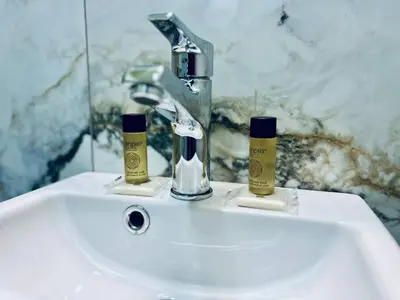 a bathroom sink with two toothbrushes and a faucet at NJ Deluxe rooms in Varna City