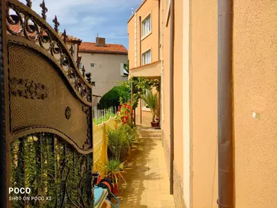 a building with a gate next to a street with plants at Доли in Pomorie