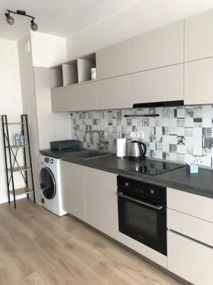 a kitchen with white cabinets and a washer and dryer at *HOT* Main Square Brand New Luxury Apartment in Burgas City
