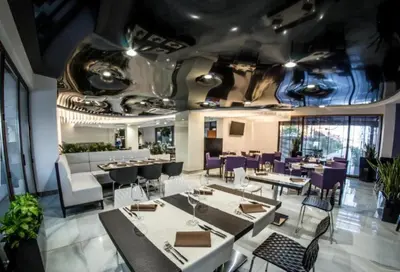 a dining room with tables and purple chairs at Premier Lux apartmán in Sveti Vlas