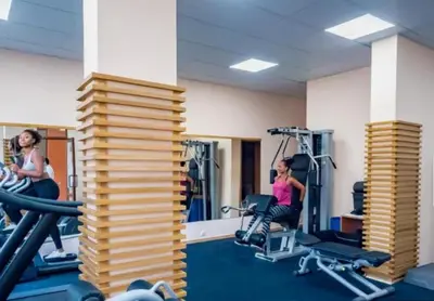 a gym with two women working out in machines at Premier Lux apartmán in Sveti Vlas