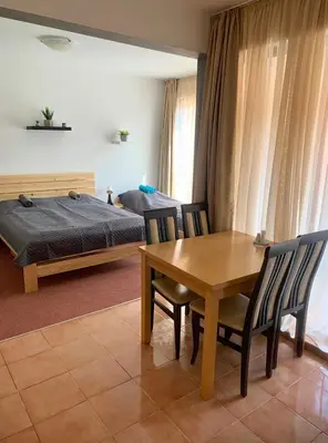 a bedroom with a table and chairs and a bed at Ubytování krásném a klidném prostředí V soukromém apartmánu in Aheloy