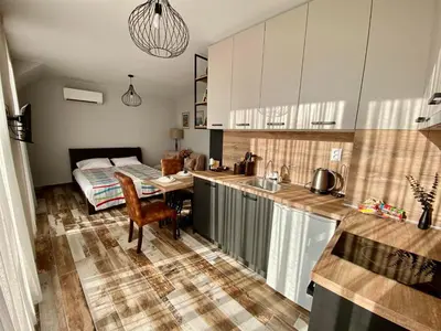 a kitchen with a table and a bed in a room at K&K Sunset in Burgas City