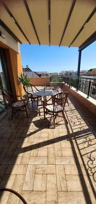 a patio with a table and chairs on a balcony at K&K Sunset in Burgas City