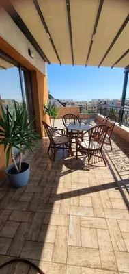 a patio with a table and chairs on a balcony at K&K Sunset in Burgas City