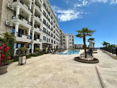 a large apartment building with a swimming pool and palm trees at ONYX 1 - Menada Apartments in Sveti Vlas